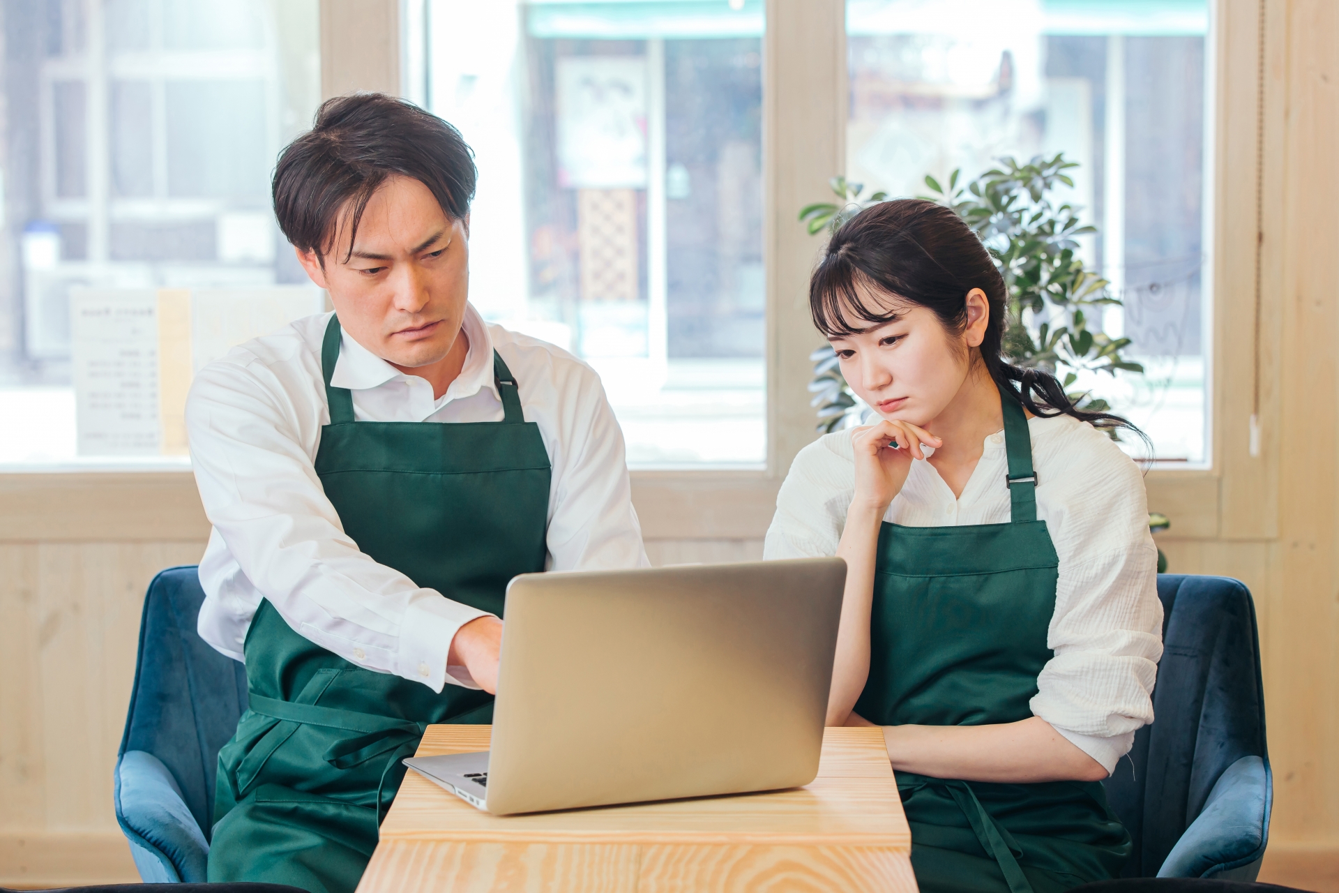 負債を抱え悩む男性経営者と女性従業員